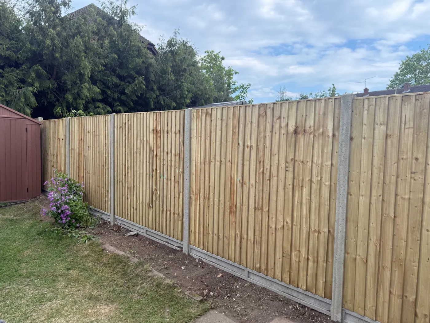 Long run of closeboard fence panels and gravel boards in a residential garden