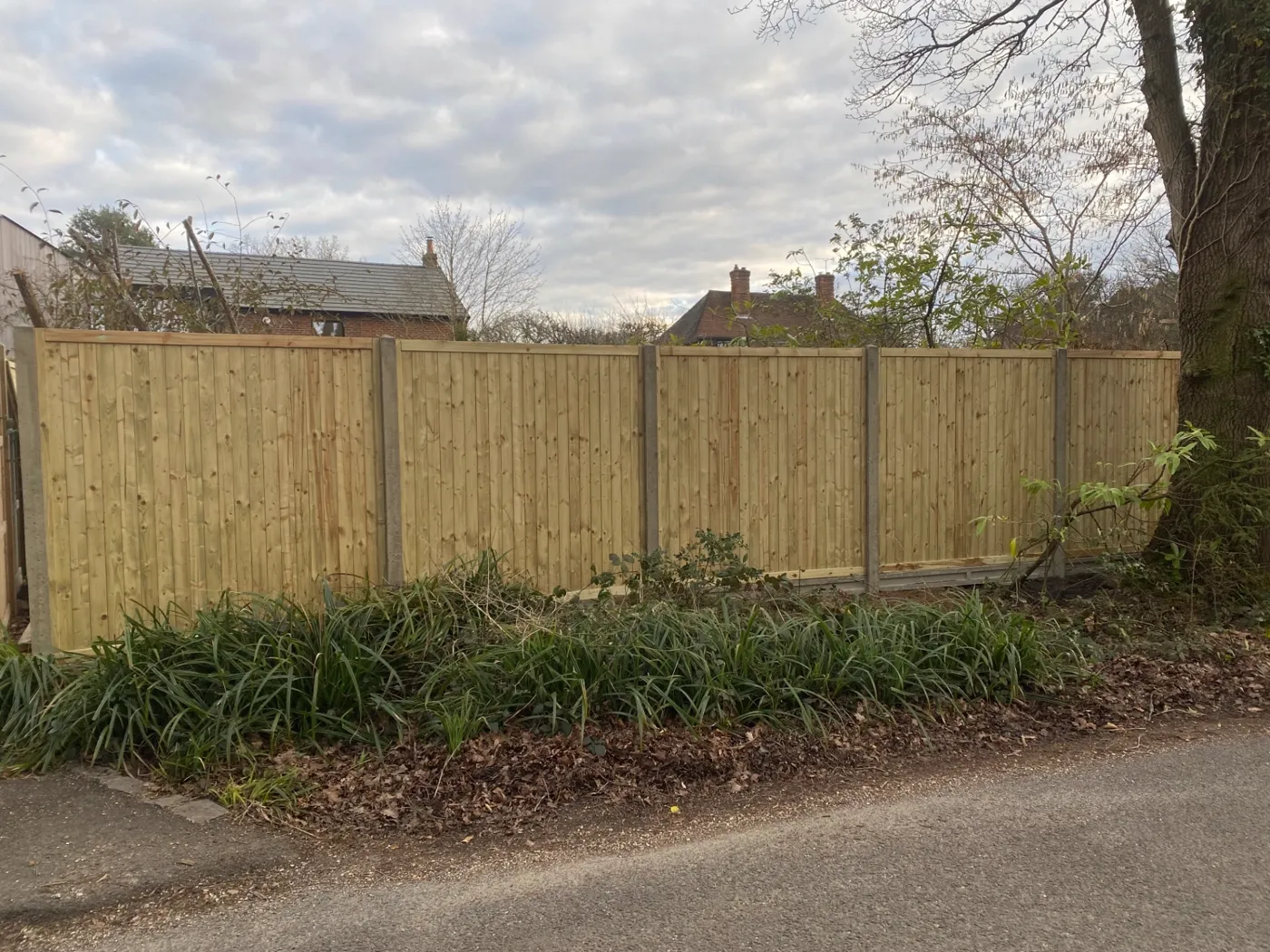 Feather edge garden fence panels facing a village lane